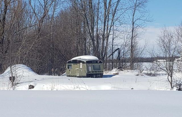 A photo of a trailer home in a snowy landscape.