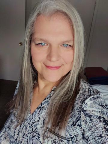 A selfie of Rev. Cindy Bourgeois, a woman with blue eyes and silver hair, trailed with dark brown highlights at the ends. 