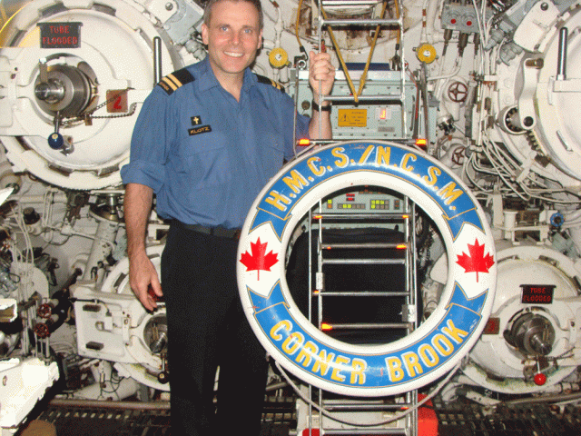 Lieutenant Commander (Padre) Earl Klotz, in uniform, standing inside a submarine.