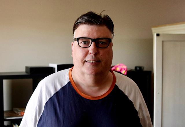 Man standing in front of a bookshelf