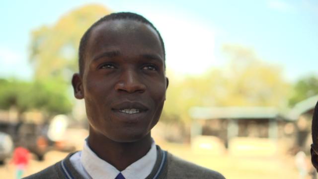 Image: Head shot of a young Black man against a background in Africa