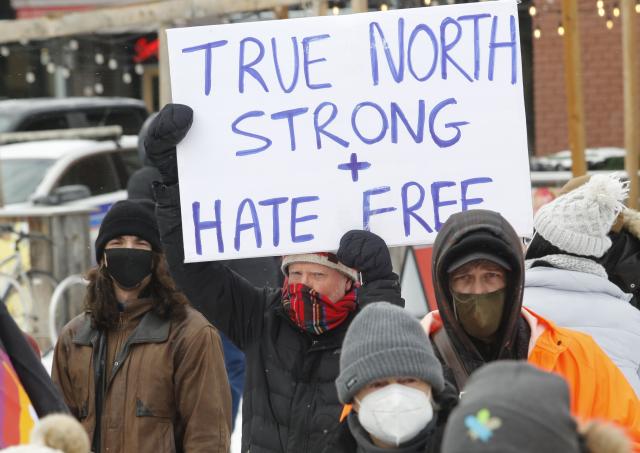 counter protest with sign that says True North Strong and Hate Free