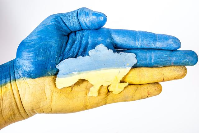 Ukraine flag overlaid on hand with outline of country