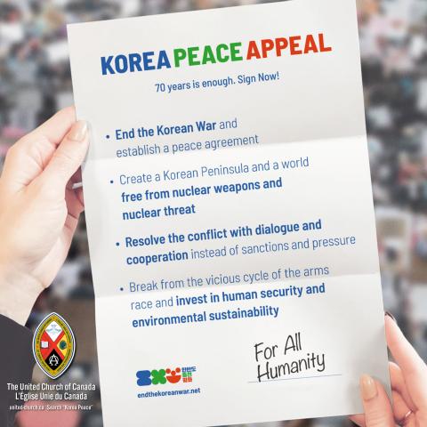 Two hands hold up a sheet of paper printed with four wishes for Korean peace: to end the war, to create a Korean peninsula free of nuclear weapons, to resolve the conflict with dialogue, and to invest in human security and the environment.