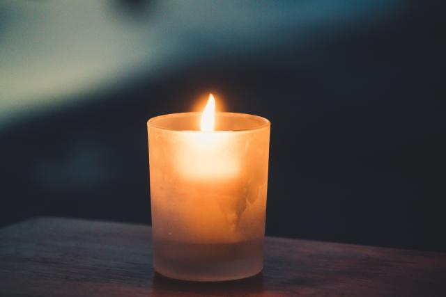 a single lit candle on a table