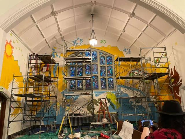 Scafolding, buckets of paint, and tools shown inside the church where Indigenous artist Philip Cote is working on his mural.