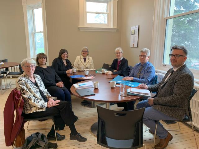 Seven people from different Canadian denominations and churches sit around a round table.