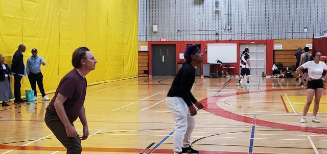 Cameron Fraser looks up for the ball while playing volleyball in an indoor gym.