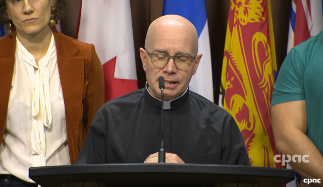 Eric Hebert-Daly speaks at a microphone at a press conference