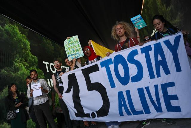 youth carry protest banners and signs at COP27