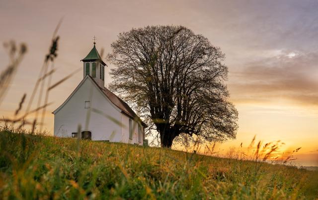 White church in field against a sunset