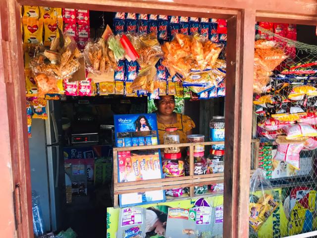 A Sri Lankan woman stands in her retail shop