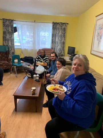 A group of adults sitting around a living room 