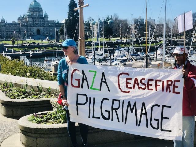 People carry a large banner for the Gaza Ceasefire Pilgrimage in Victoria, BC.