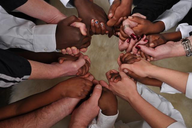 Many people hold hands in a circle