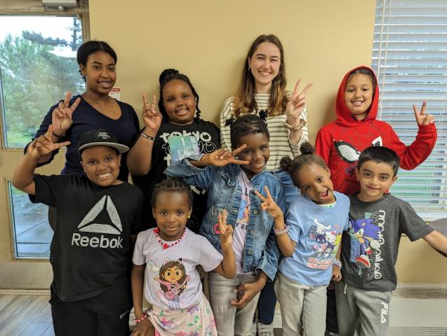 Group of smiling children make the peace sign with their hands