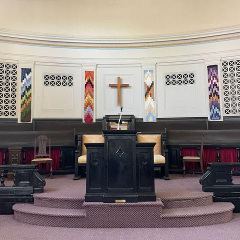 Sanctuary with various coloured tapestries handing in background