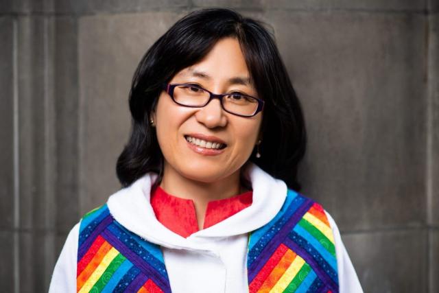 Head shot of HyeRan Kim-Cragg wearing a rainbow-coloured alb around her neck