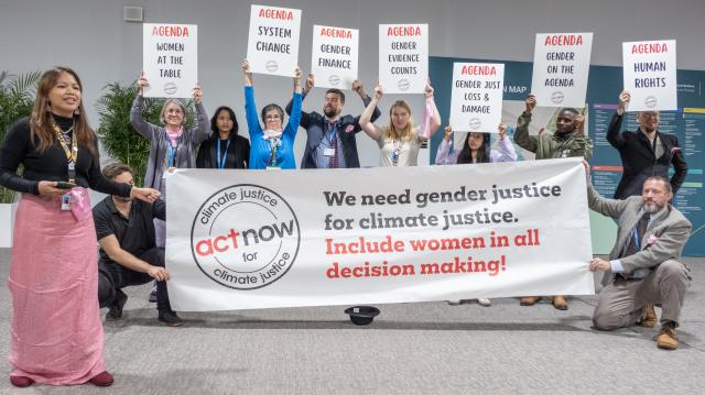 Patricia Mari Mungcal and others hold a banner advocating for gender and climate justice.