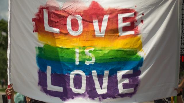White banner with pride colours and the text "Love is Love" on it.