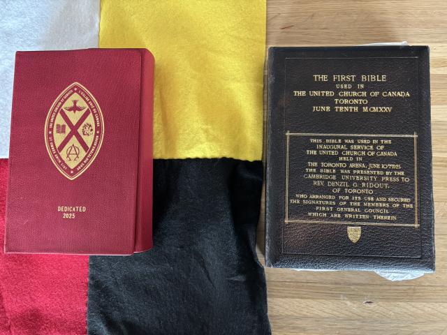 The United Church Mohawk Bible lies on a black, yellow, white, and red flag, next to the former Union Bible.