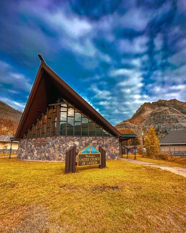 Waterton United Church with mountains and blue sky