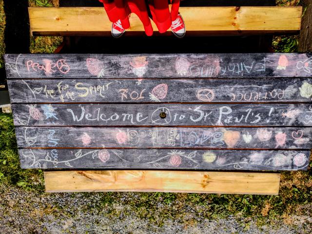 Picnic table with fruit and messages of welcome, love, peace drawn in chalk