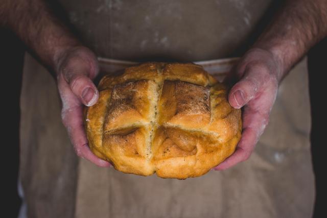 Hands holding a loaf of bread