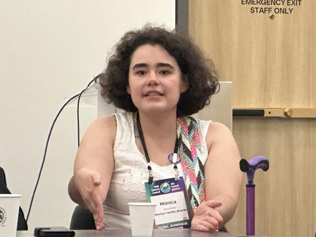 A young woman with dark hair wearing a lanyard.