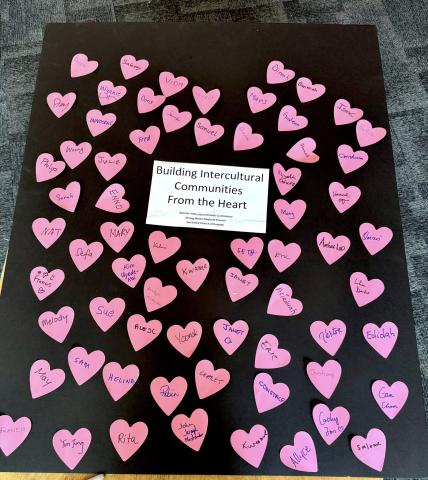 A poster filled with pink hearts, each with a name written on them
