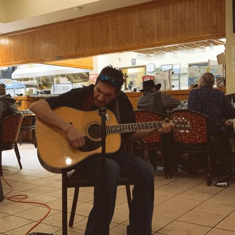 A man plays guitar in a community centre