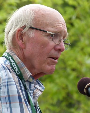 The Very Rev. Dr. Robert F. Smith speaking into a microphone