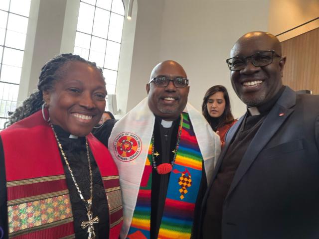 Three people taking a selfie in clerical collars and robes