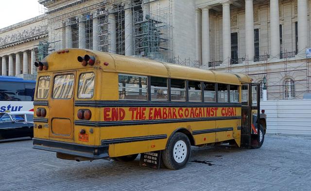 A school bus in Havana with graffiti painted on it that says "End the embargo against Cuba!"