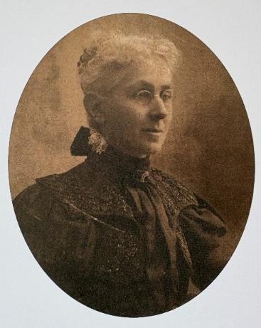A sepia portrait of a bespectacled white woman