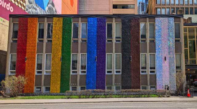 An exterior church wall painted in rainbow colours