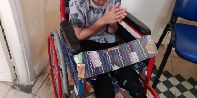 A boy in a wheelchair from the shoulders down
