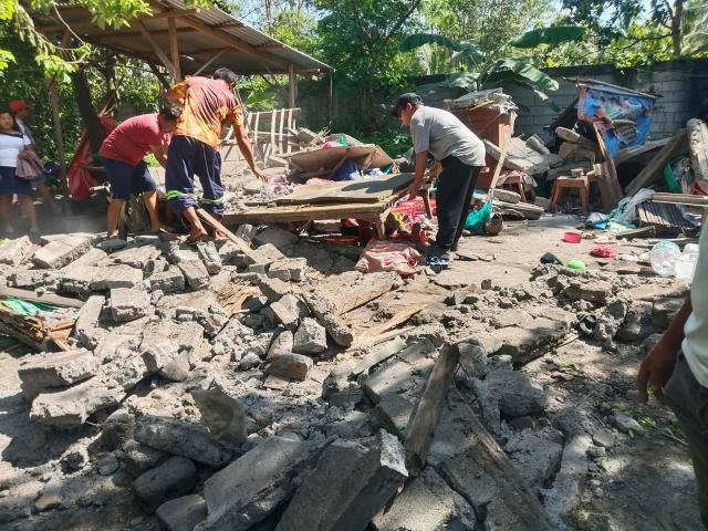 People clean up rubble after earthquake