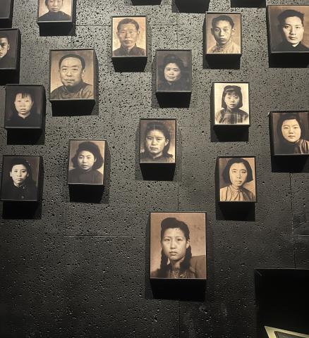 A wall hung with black and white photos of Chinese men and women from the 20th century.