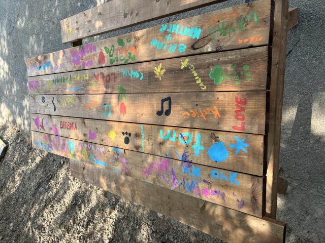 A picnic table painted with names, symbols