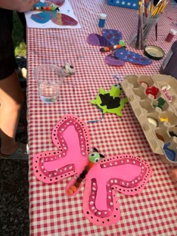 Painted butterflies on a picnic table with art supplies around