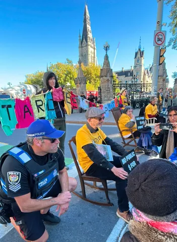 Members of Senior Climate Witness sitting in rocking chairs at a protest in Ottawa.