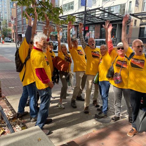 A group of people in yellow shirts in the streets raise their fists