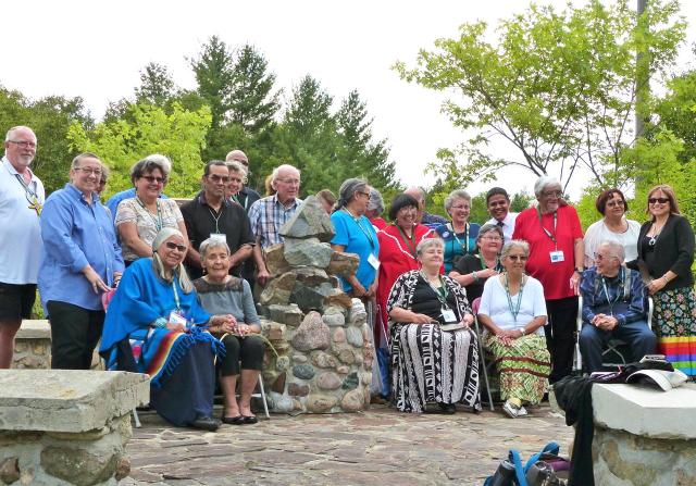 Honoured guests, event organizers, and United Church staff gather at the cairn.