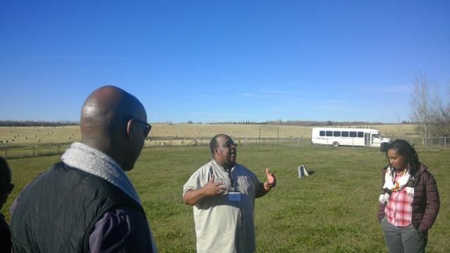 The author in the centre, leads a group of Black clergy on a visit to the cemetery at Amber Valley, AB.