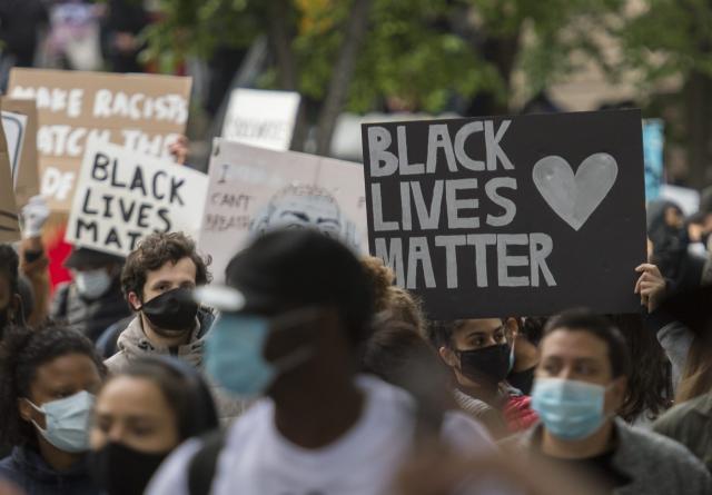 A diverse mass of people with "Black Lives Matter" signs demonstrate against racism in Montreal.