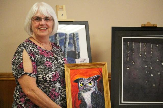 Corrine Donnelly, am artist who lives in the Bradford area, holds up a painting that was on display in the Bradford Arts Centre. Corrine Donnelly, am artist who lives in the Bradford area, holds up a painting of an owl that was on display in the Bradford Arts Centre.