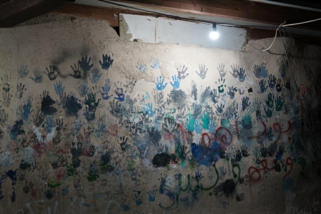 Children’s handprints decorate the wall of the “Tire School” at Khan Al Ahmar. Photo of children's handprints in Khan al-Ahmar