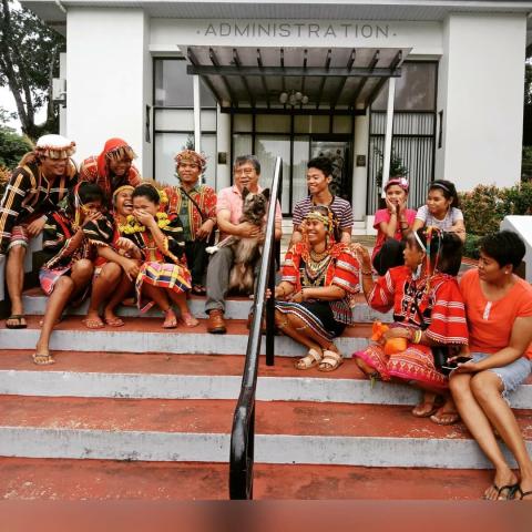 A group of Indigenous Lumad farmers and supporters sit for a photo on the steps of the seminary's Administration building.