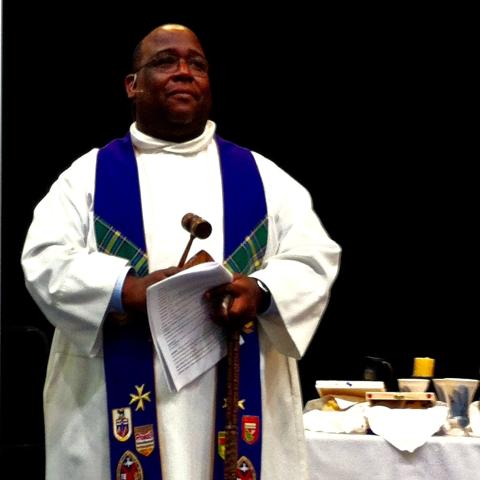 Rev. Paul Douglas Walfall in his clergy robes, presiding over a meeting in the United Church's Alberta and Northwest Conference.